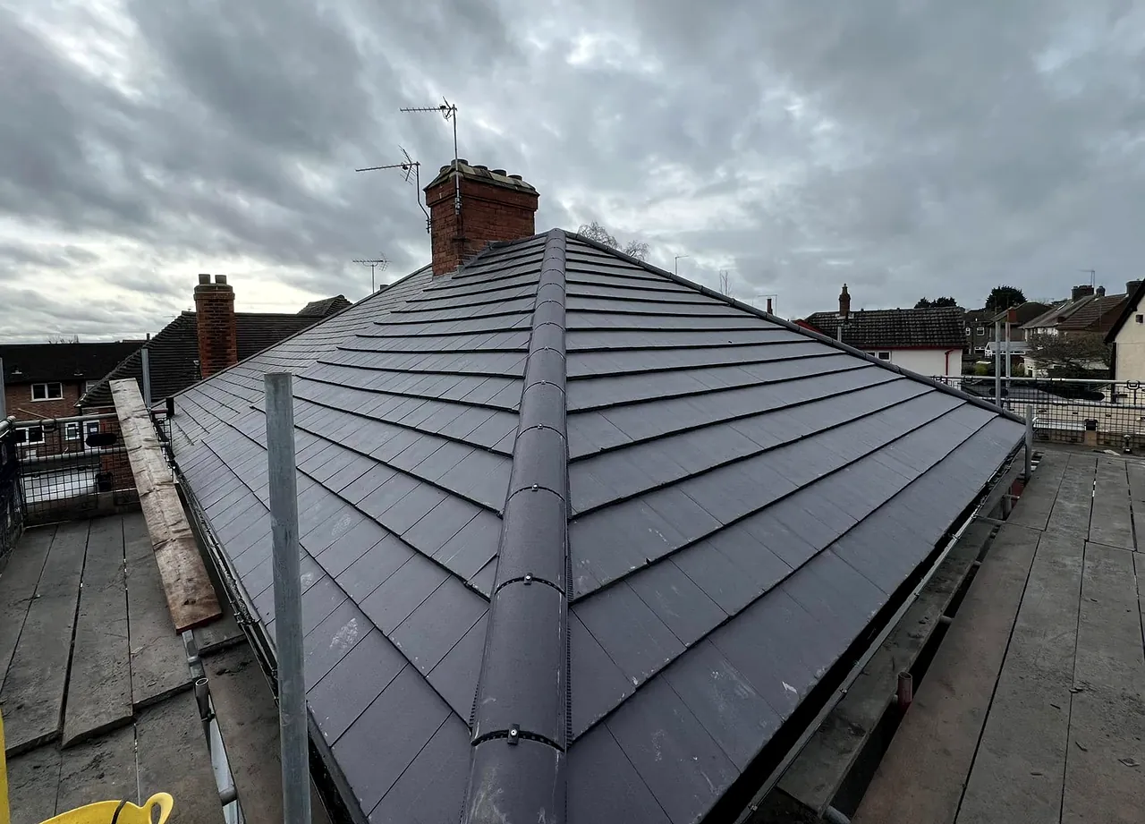 The same roof after: new grey tiles with the ridge and hips finished, from the same spot